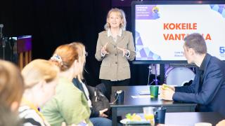 Esittelijä kertoo tilaisuudessa kuulijoille yrittäjyydestä.