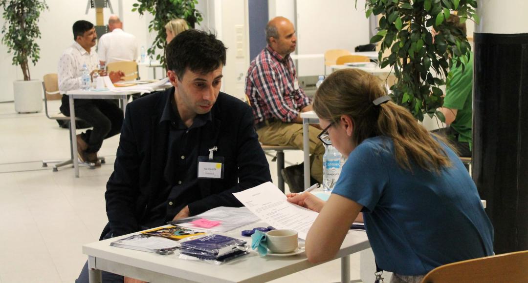 Yrityksen ja osaajan välinen keskustelu. Yrityksen edustaja lukee osaajan ansioluetteloa.